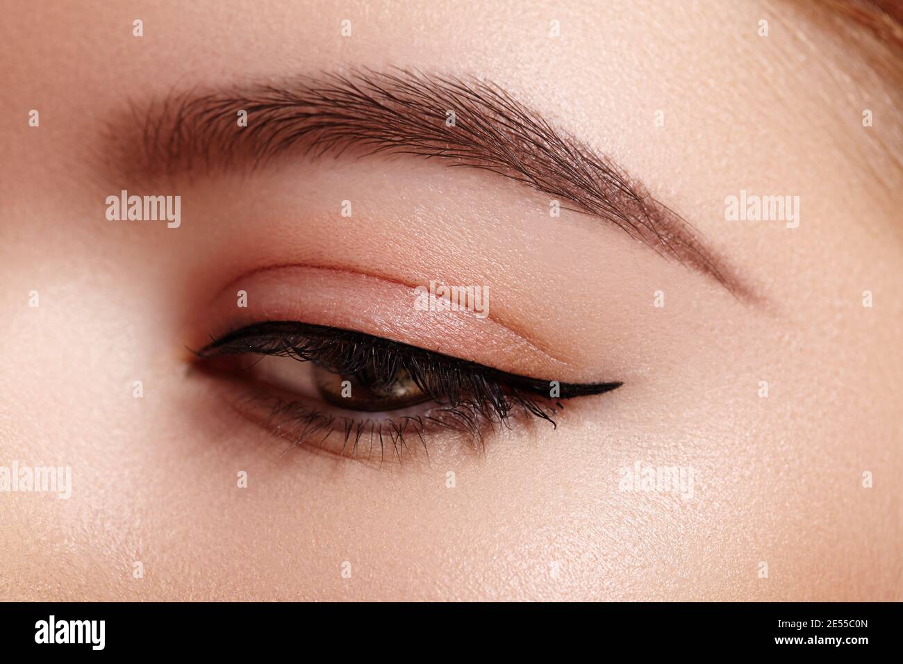 Superbe photo macro de l'œil féminin avec maquillage eyeliner classique.  Forme parfaite des sourcils, des fards à paupières bruns et des cils longs.  Cosmétiques et maquillage Photo Stock - Alamy