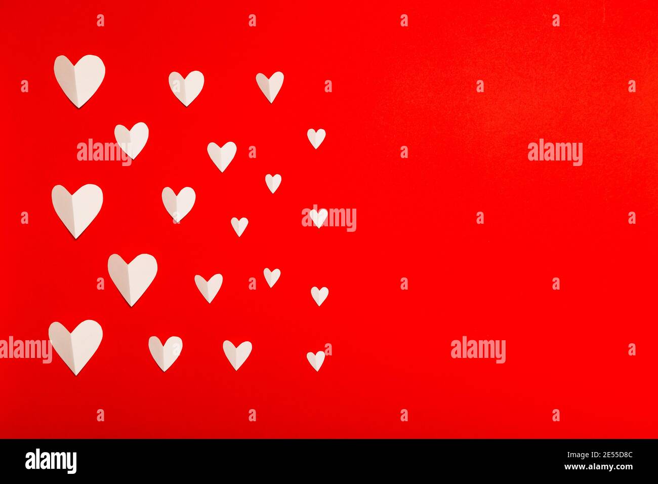 Composition de la Saint-Valentin. Coeurs en papier blanc sur fond rouge et style de pose à plat. Concept de la Saint-Valentin, modèle photo Banque D'Images