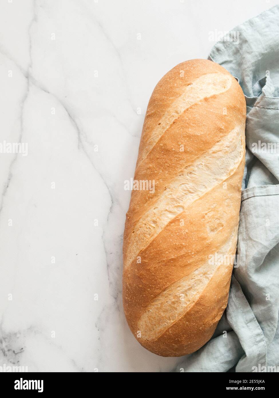Pain de pain de blomer blanc britannique ou de pain de bâton européen sur fond de marbre blanc. Vue de dessus ou plan d'étapage. Copier l'espace pour le texte ou la conception. Verticale. Banque D'Images