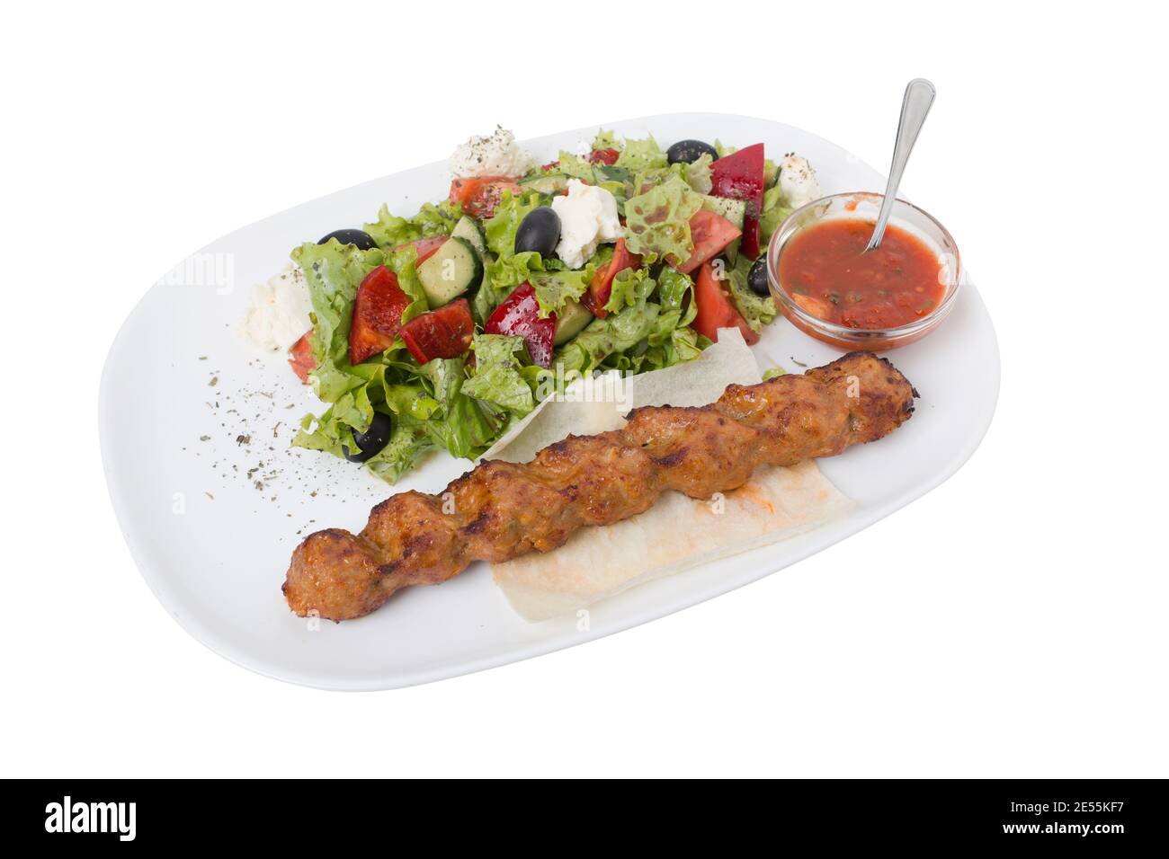 Lula kebab caucasien et adjika avec salade. Elle est isolée sur un fond blanc. Gros plan. Banque D'Images