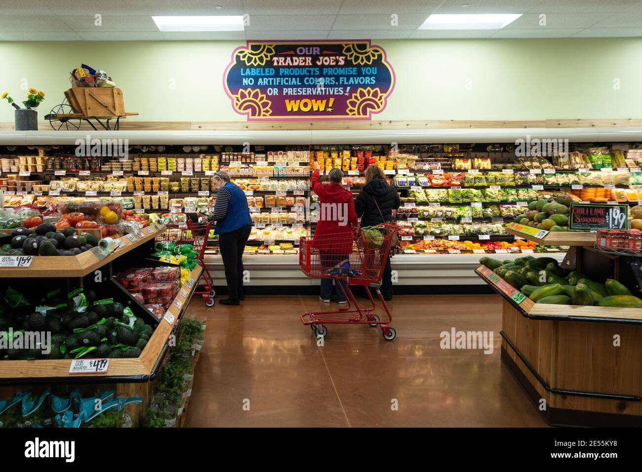 Trois personnes magasinent dans la section des produits et présentent des légumes frais dans Trader Joe's. Wichita, Kansas, États-Unis Banque D'Images