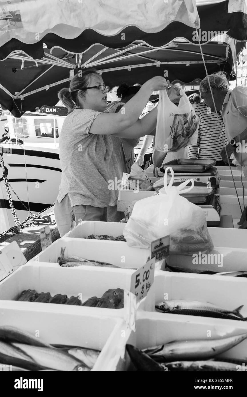 La prise fraîche est vendue au marché aux poissons de la rue sur la jetée. Trouville-sur-Mer, France. Photo historique noir blanc. Banque D'Images