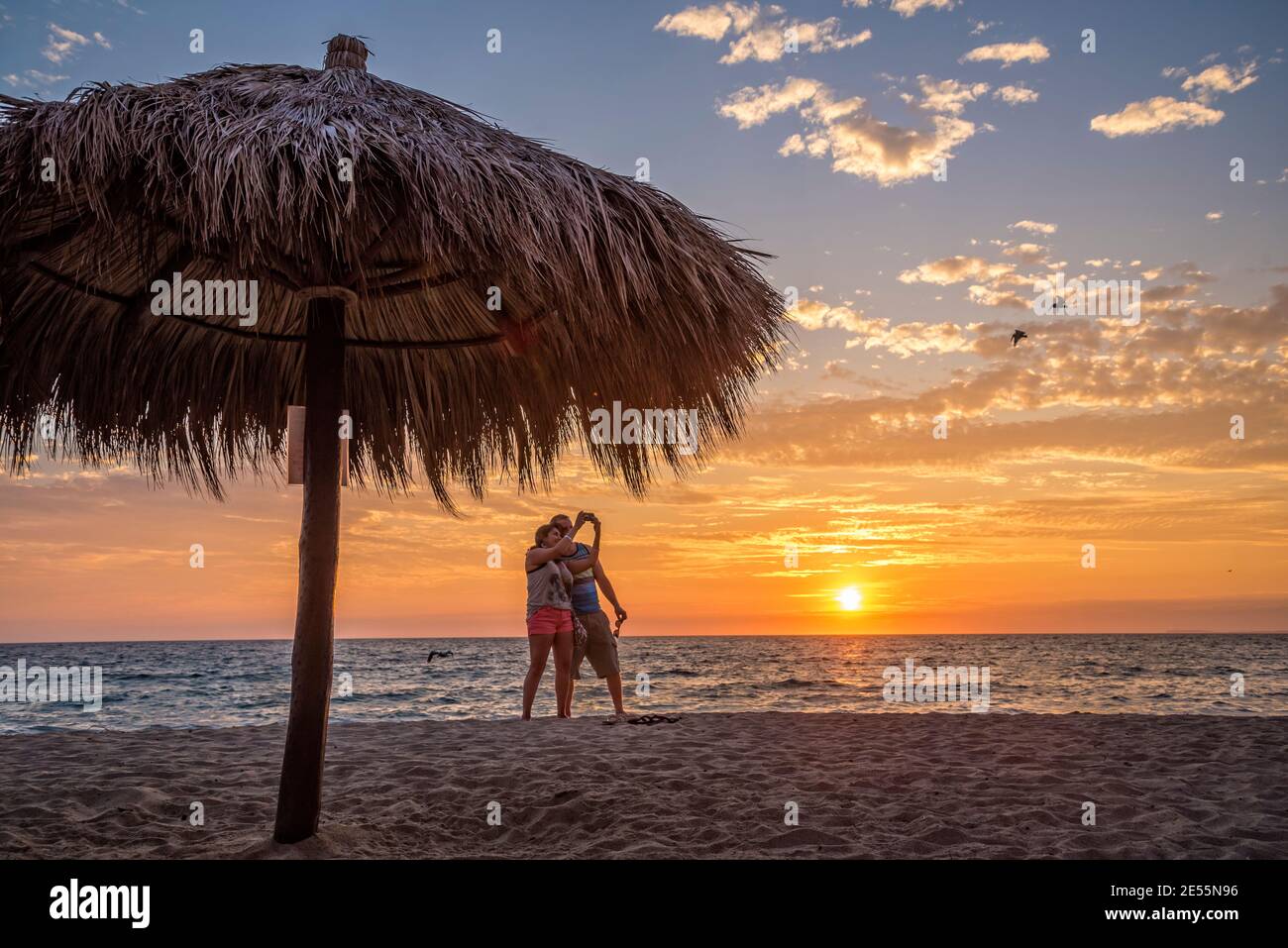 Couple prenant photo de selfie sur la plage au coucher du soleil à Puerto Vallarta, Jalisco, Mexique. Banque D'Images