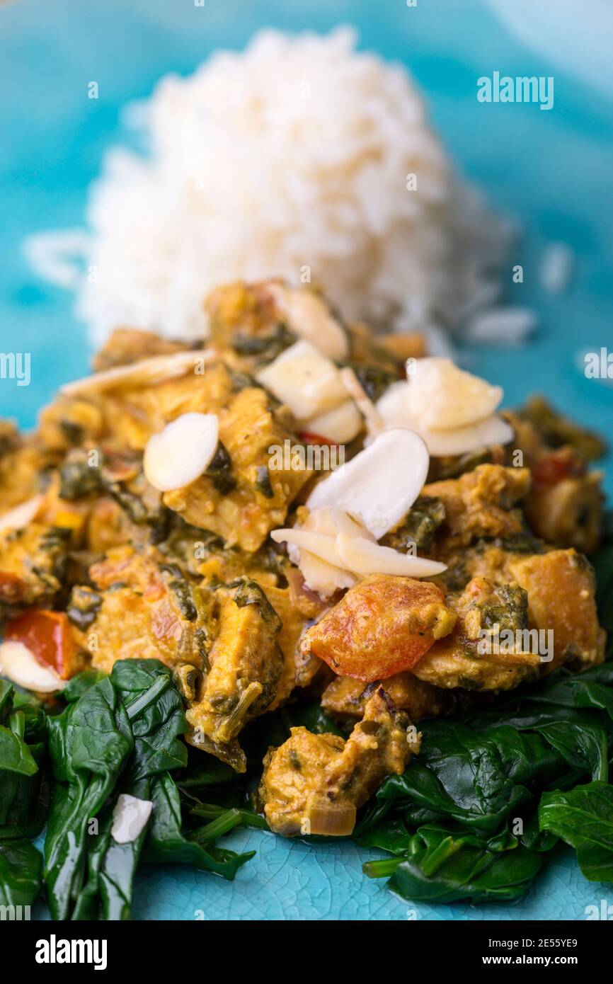 poulet palak indien sur une assiette bleue Banque D'Images