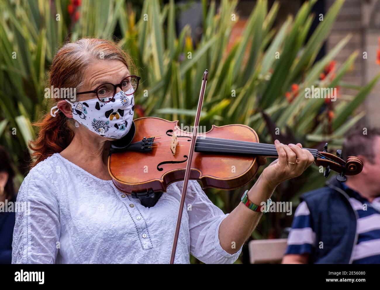 Une violoniste féminine portant un masque sur le thème d'un chien joue à une manifestation de rébellion d'extinction. Banque D'Images