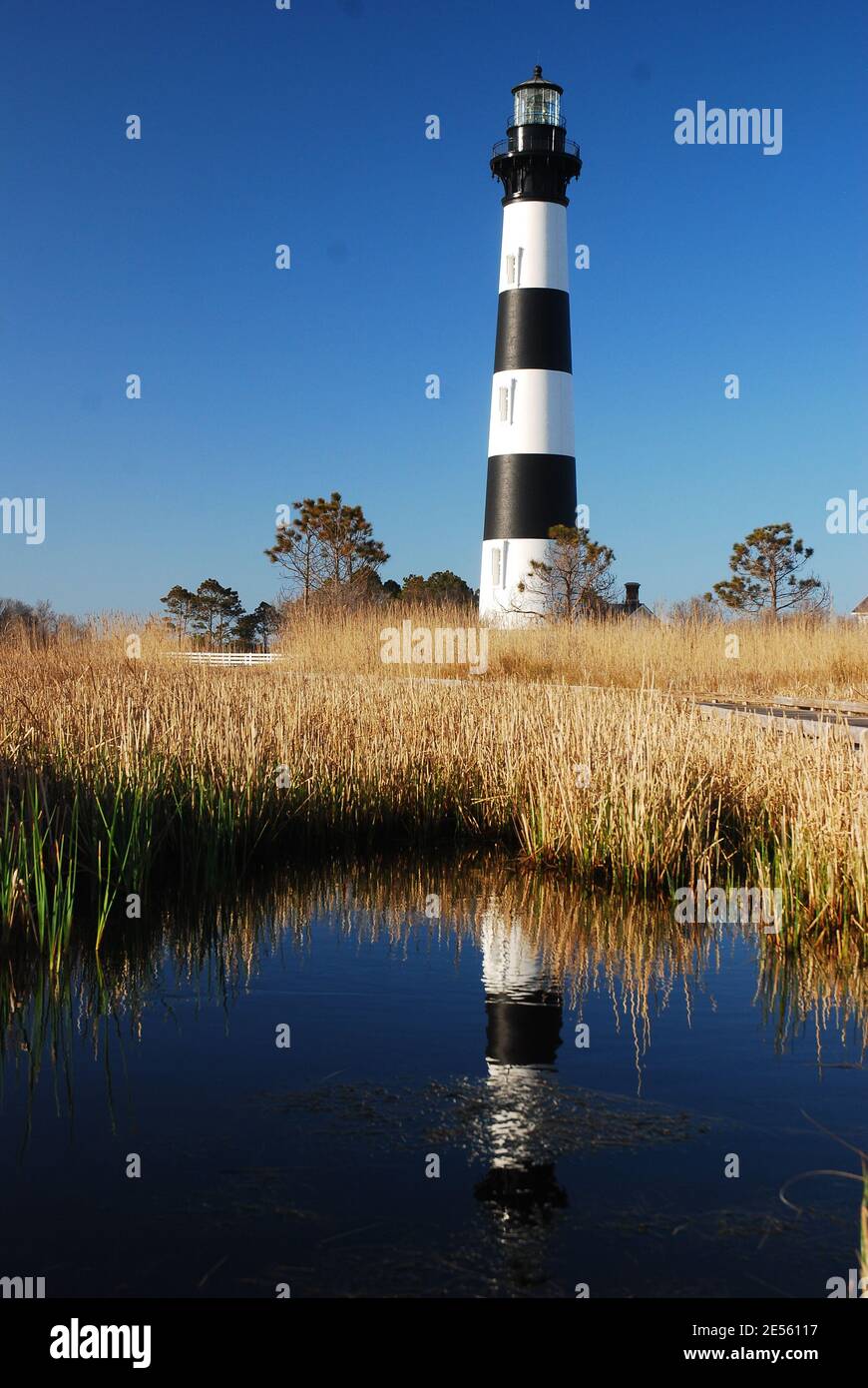 L'imposant phare de l'île de Bodie, sur les rives extérieures de la Caroline du Nord, se reflète dans le marais voisin Banque D'Images