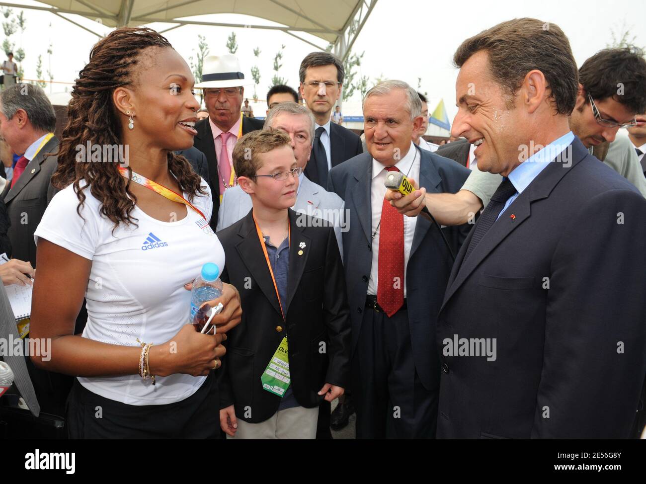 Le président français Nicolas Sarkozy, aux côtés de son fils Louis et de son ancien Premier ministre Jean-Pierre Raffarin, s'adresse à la tireur française Laura Flessel pour une visite aux athlètes olympiques français avant la cérémonie d'ouverture au village olympique de Pékin, en Chine, le 8 août 2008. Photo d'Alain Benainous/Pool/ABACAPRESS.COM Banque D'Images