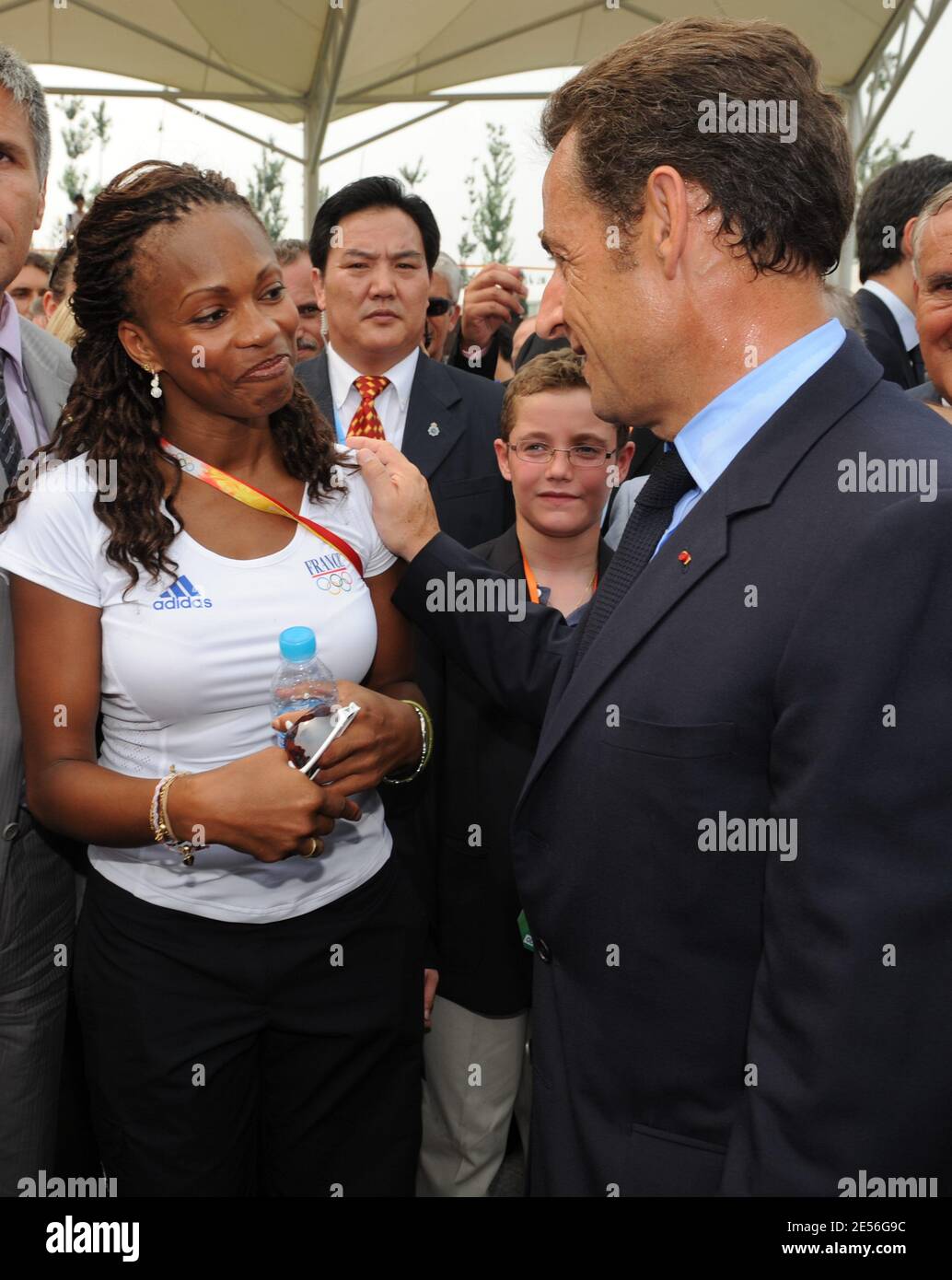 Le président français Nicolas Sarkozy, aux côtés de son fils Louis et de son ancien Premier ministre Jean-Pierre Raffarin, s'adresse à la tireur française Laura Flessel pour une visite aux athlètes olympiques français avant la cérémonie d'ouverture au village olympique de Pékin, en Chine, le 8 août 2008. Photo d'Alain Benainous/Pool/ABACAPRESS.COM Banque D'Images