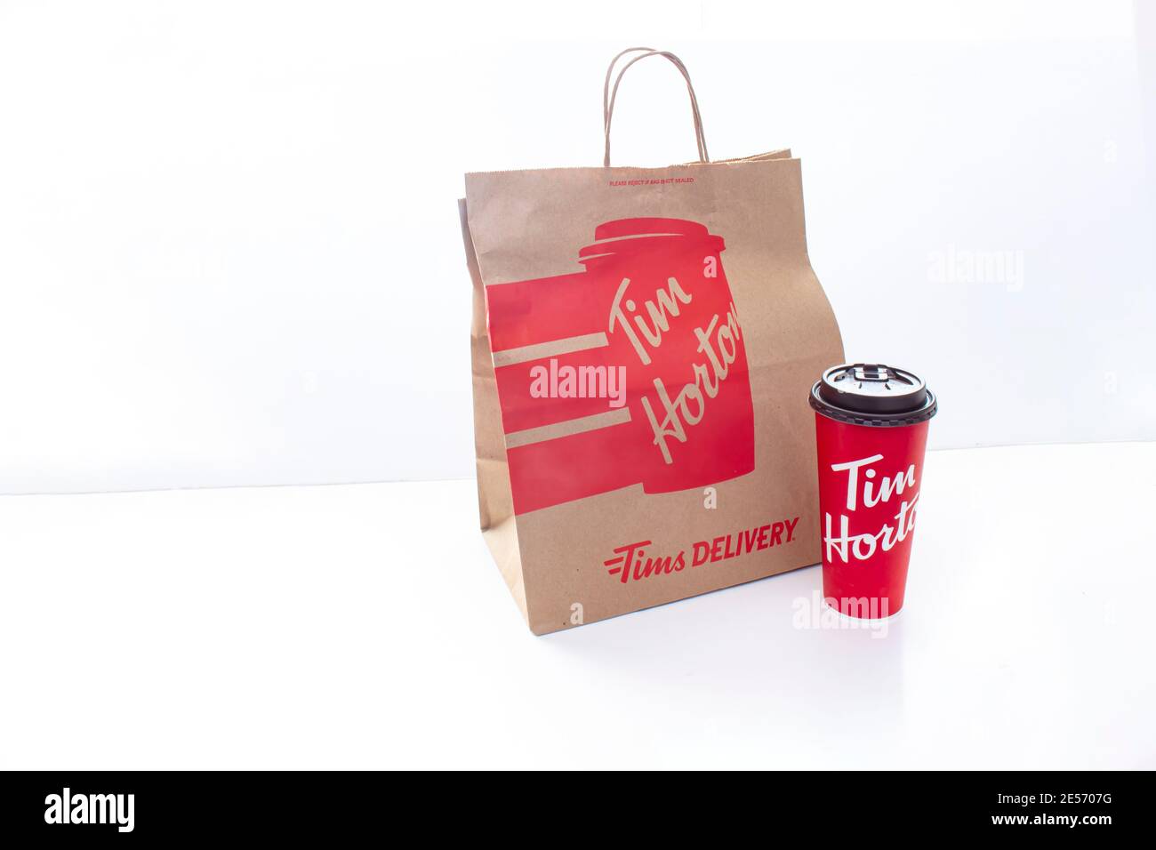 Calgary (Alberta). Canada. 25 janvier 2021. Un sac de papier de livraison Tim Horton et une tasse de café sur fond blanc. Banque D'Images