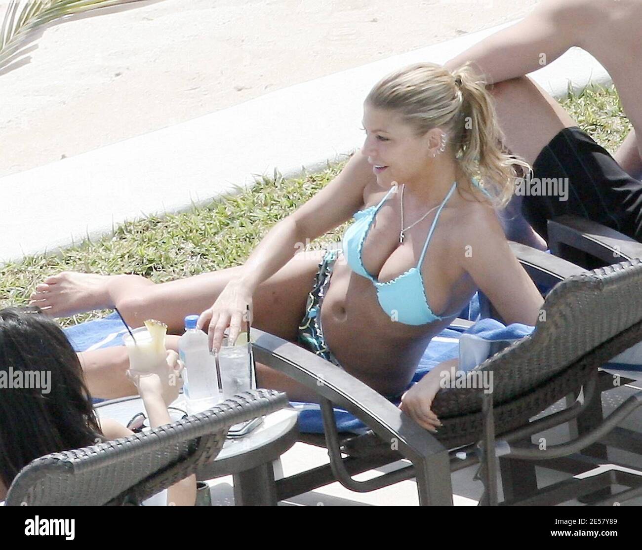 Exclusif !! Fergie et son petit ami Josh Duhamel se détendent au bord de la piscine dans leur hôtel de luxe au Mexique. Le couple était tous souriant car ils se prélaissaient au soleil et regardaient l'océan. À un moment donné, Duhamel semblait exprimer une grande admiration pour les fesses de Fergie.3/6/07 [[rac]] Banque D'Images