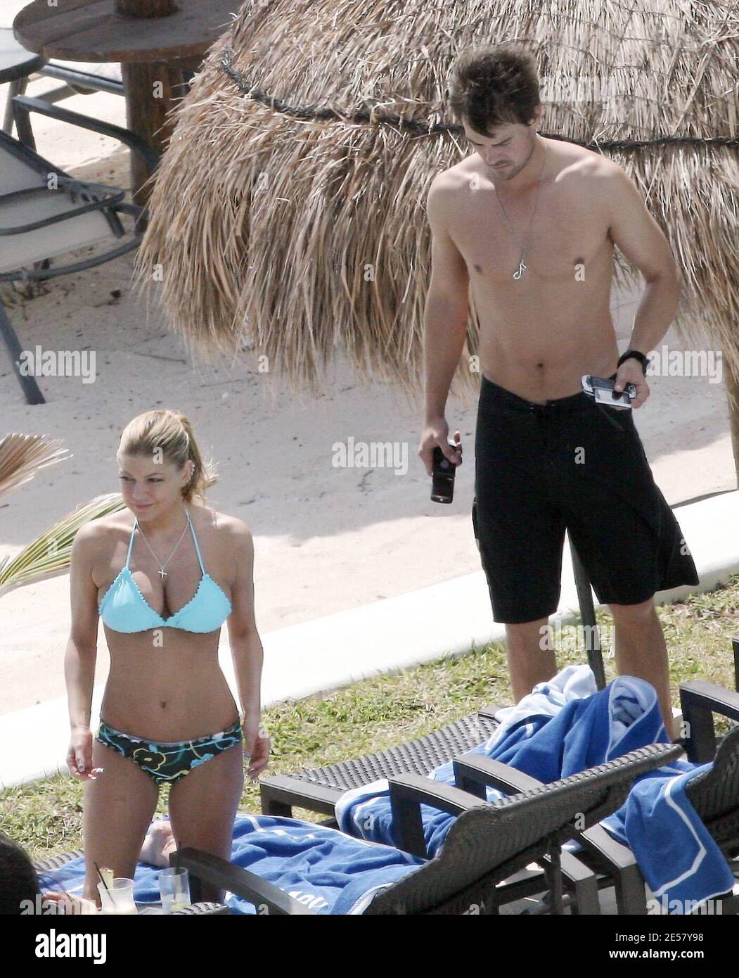 Exclusif !! Fergie et son petit ami Josh Duhamel se détendent au bord de la piscine dans leur hôtel de luxe au Mexique. Le couple était tous souriant car ils se prélaissaient au soleil et regardaient l'océan. À un moment donné, Duhamel semblait exprimer une grande admiration pour les fesses de Fergie.3/6/07 [[rac]] Banque D'Images
