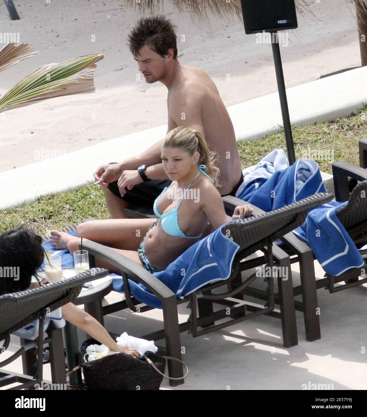 Exclusif !! Fergie et son petit ami Josh Duhamel se détendent au bord de la piscine dans leur hôtel de luxe au Mexique. Le couple était tous souriant car ils se prélaissaient au soleil et regardaient l'océan. À un moment donné, Duhamel semblait exprimer une grande admiration pour les fesses de Fergie.3/6/07 [[rac]] Banque D'Images