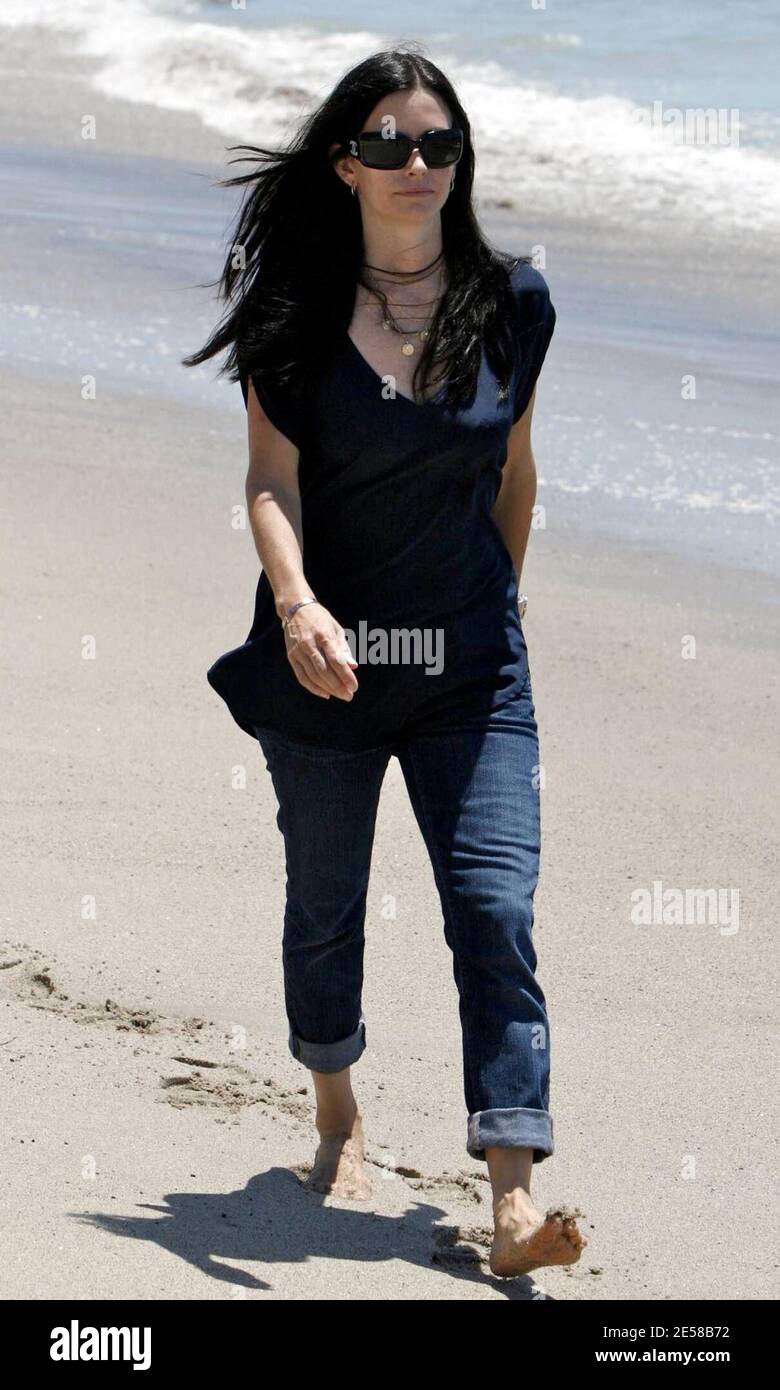 Courtney Cox et le hubby David Arquette se promènent sur la plage. La nounou du couple était occupée à garder la fille Coco amusé en la traînant au-dessus de son épaule. Malibu, Californie, 7/2/07. [[laj]] Banque D'Images