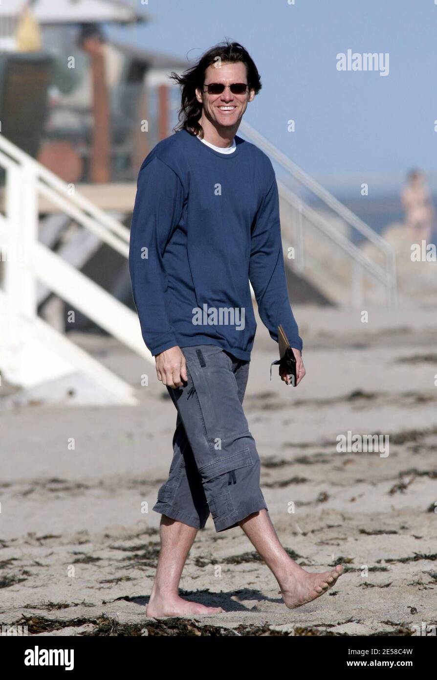 Jim Carrey a ses mains pleines de deux nouveaux paquets de joie. Ses chiots l'ont gardé occupé pendant une promenade sur la plage près de sa maison. Carrey a pris les chiots sur le sable pour les présenter à deux chiens plus grands. Il a également dû continuer à tirer les algues hors de leur bouche. Malibu, Californie, 7/7/07. [[rac ral]] Banque D'Images