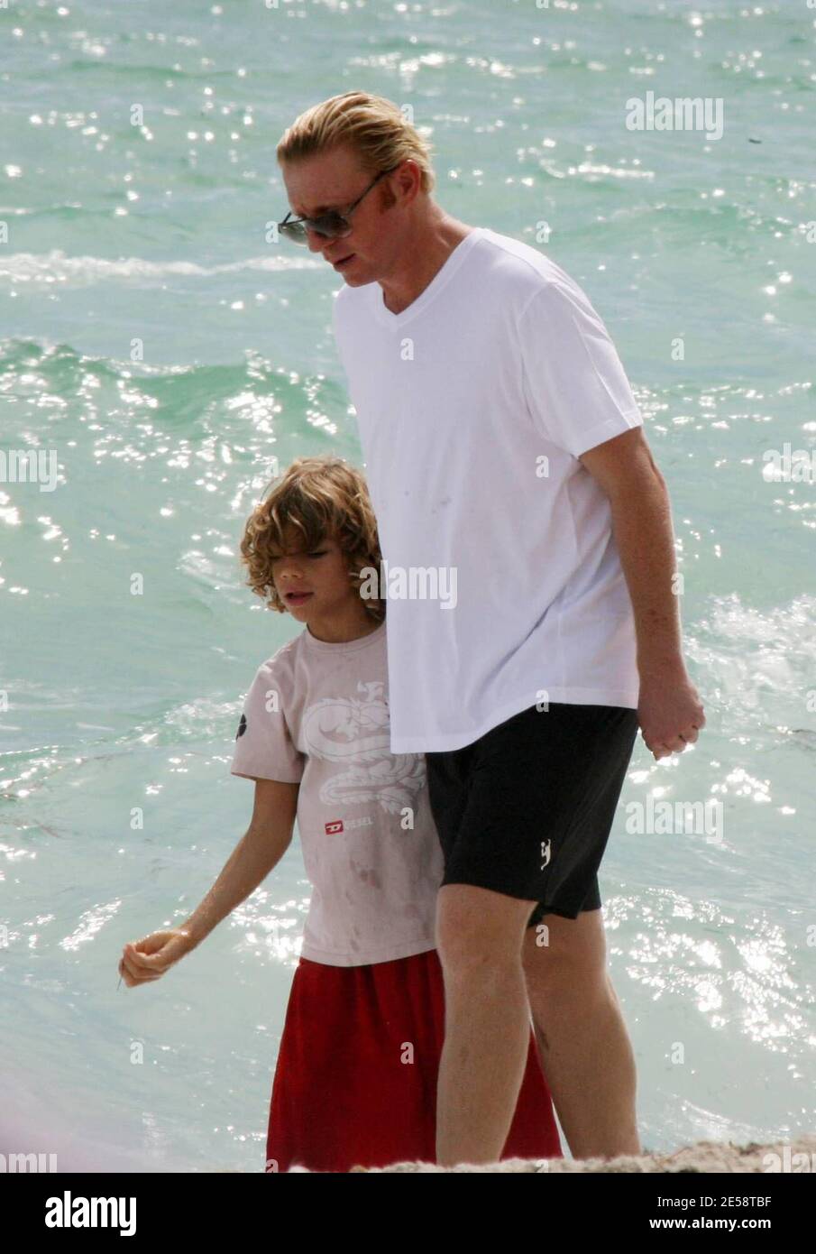 Exclusif !! Boris Becker prend son fils Elias pour une promenade dans le surf. Elias a fait des bombes de sable et les a jetées dans l'océan tandis que papa a tenu son jouet mignon lion, Miami Beach, FL. 10/19/07. [[balise mab]] Banque D'Images