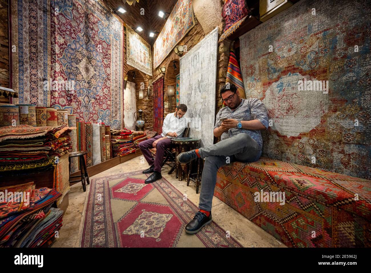 Istanbul / Turquie - Mai 02 2019 : magasin de tapis et un vendeur avec le propriétaire sont dans le Grand bazar, à l'intérieur de la boutique décorée avec de grands tapis h Banque D'Images