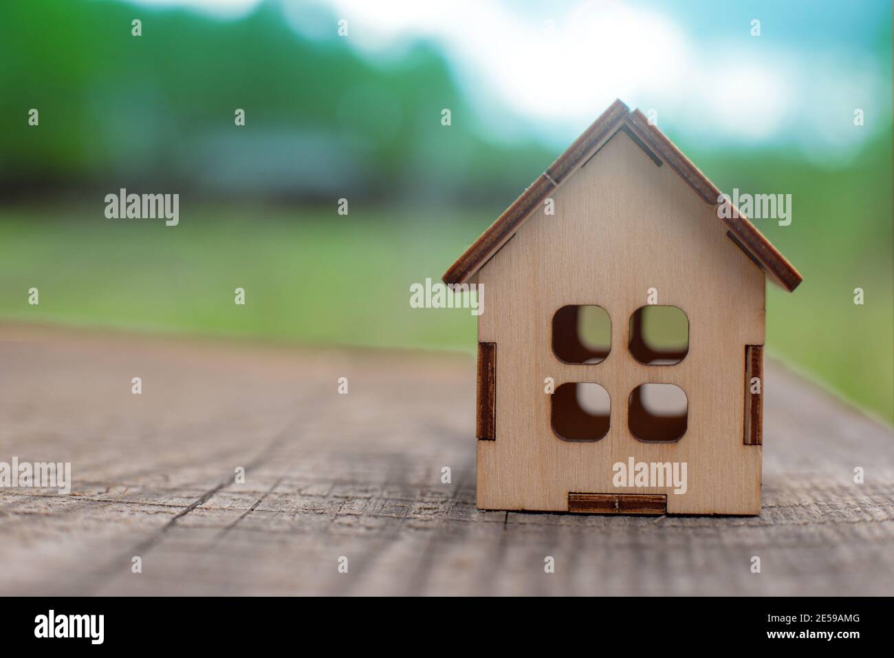 Une petite maison de jouets en bois, se tenir sur une table en bois de nature printanière Banque D'Images
