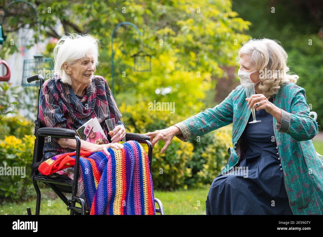 Photo du dossier datée du 16/07/2020 de Judith du Vivier rendant visite à sa mère de 100 ans Urania Brett lors d'une fête d'anniversaire surprise à la maison de soins Compton Lodge à Camden, dans le nord de Londres. Urania, une résidente du foyer de soins, qui n'avait vu aucune de sa famille depuis le début de son isolement cellulaire, a passé son 100e anniversaire à recevoir des visites de sept membres de sa famille, qui ont été échelonnés tout au long de la journée pour se conformer aux règlements d'alors sur les résidents des foyers de soins en visite. Le samedi 30 janvier marque le premier anniversaire de la mort connue du coronavirus au Royaume-Uni. Date de publication : le mercredi 27 janvier 2021. Banque D'Images