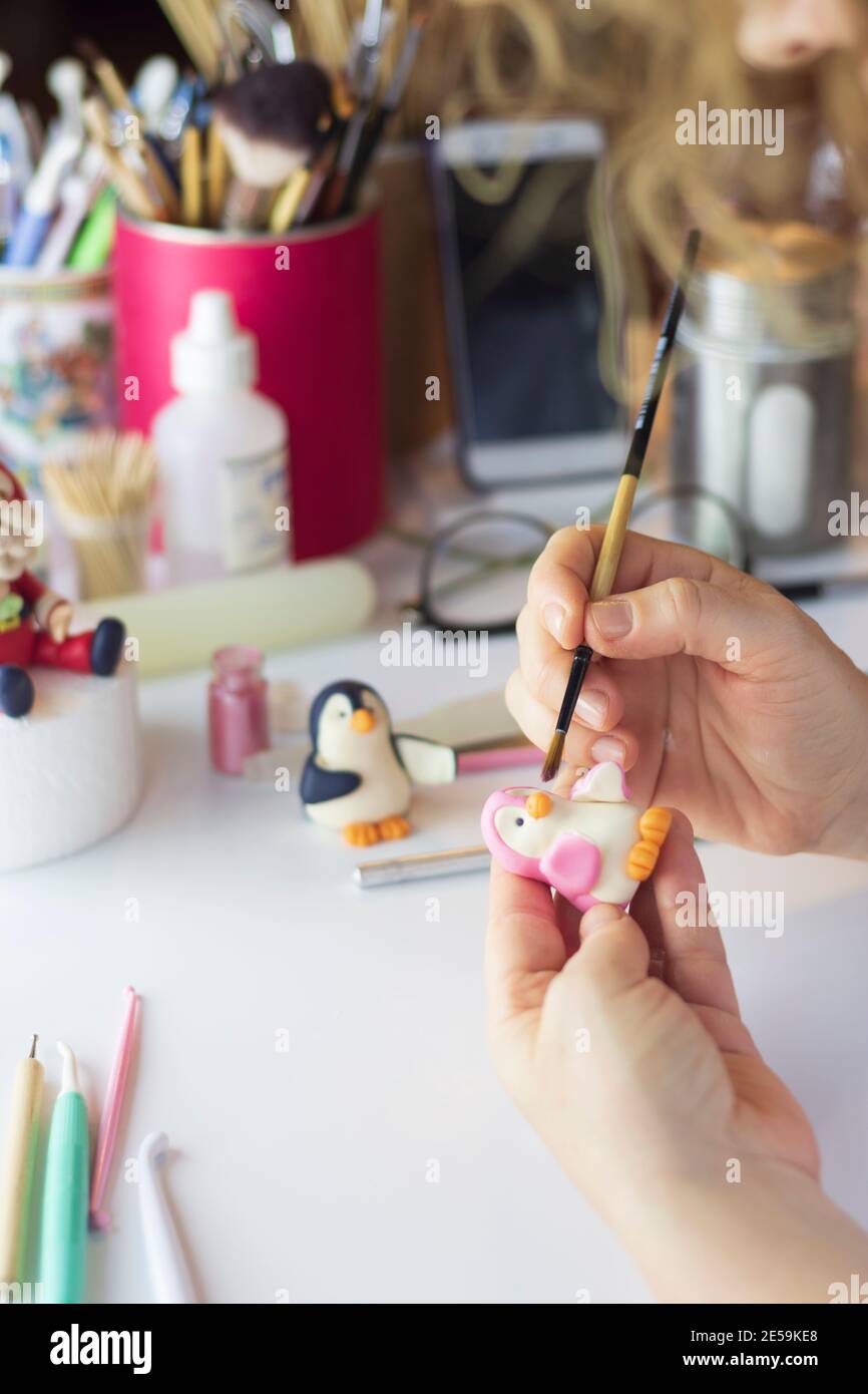 Processus de décoration de gâteau. Baker utilise des outils pour sculpter des motifs fondants : art comestible, design de gâteau, décoration de gâteau. Mise au point sélective des outils frontaux et de la main Banque D'Images