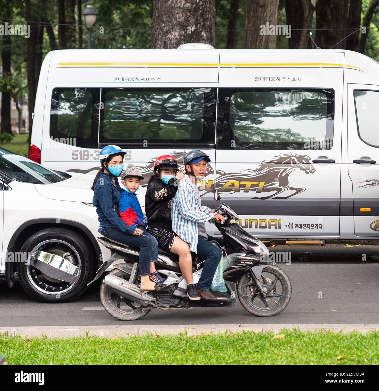 Moto avec quatre personnes dans la circulation dans le district 1, Ho Chi Minh ville, Vietnam. Banque D'Images