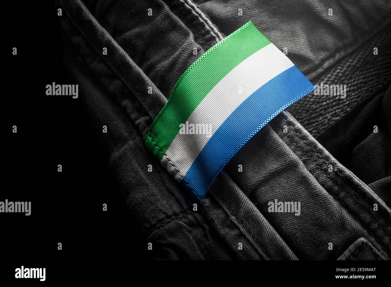 Étiquette sur les vêtements foncés sous la forme du drapeau De la Sierra Leone Banque D'Images