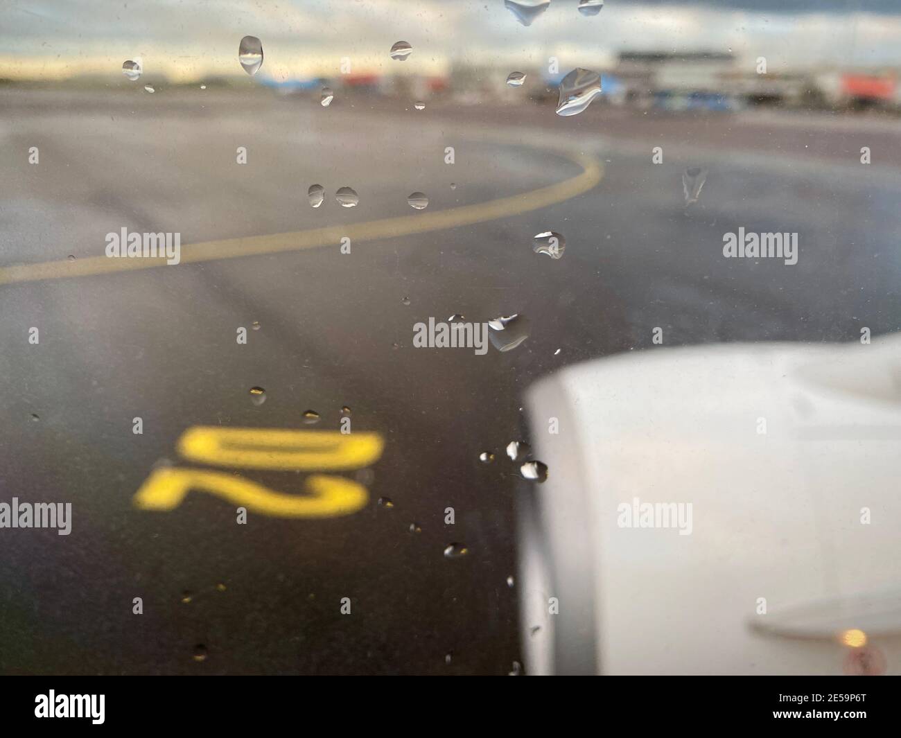 Le trajet en taxi à l'aéroport par mauvais temps, par temps pluvieux. Vue de la fenêtre de l'avion sur la piste tarmac.gouttes de pluie sur la fenêtre. Photo de haute qualité Banque D'Images