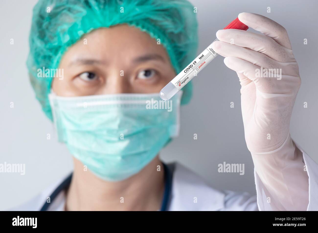 Test COVID-19 du coronavirus. Main du médecin avec un gant tenant une sonde d'essai avec un échantillon de sécrétion nasale du patient pour une infection négative du virus corona Banque D'Images