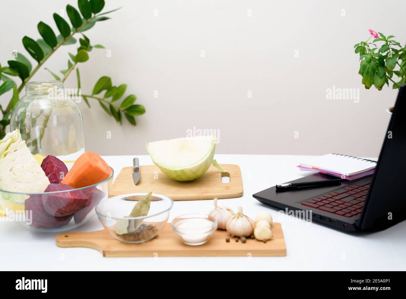 Cuisinez à la maison des recettes vidéo en ligne sur un ordinateur portable chou rose mariné fermentatif avec des betteraves et des carottes en saumure dans un pot. Banque D'Images