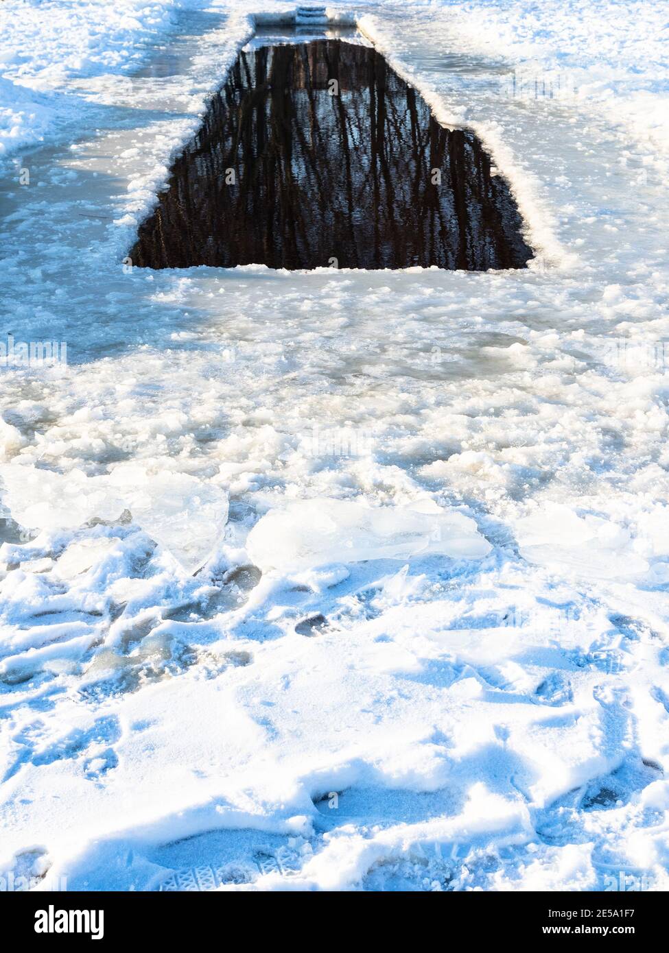long trou de glace dans une rivière enneigée gelée sur des winted ensoleillés froids jour Banque D'Images