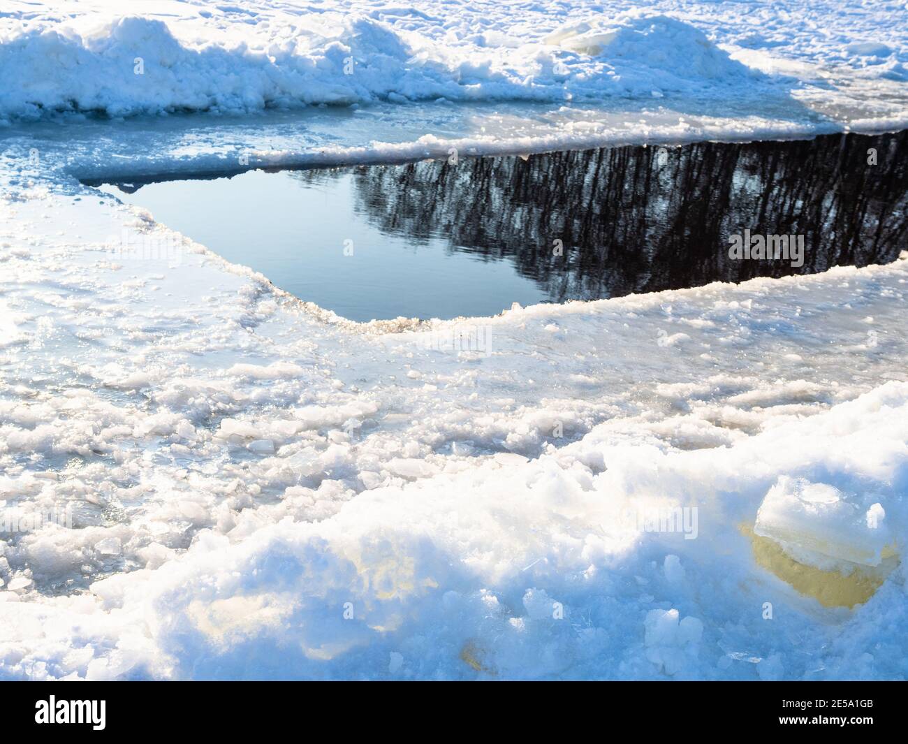 trou de glace profond dans un étang recouvert de neige gelée sur le temps ensoleillé froid jour Banque D'Images