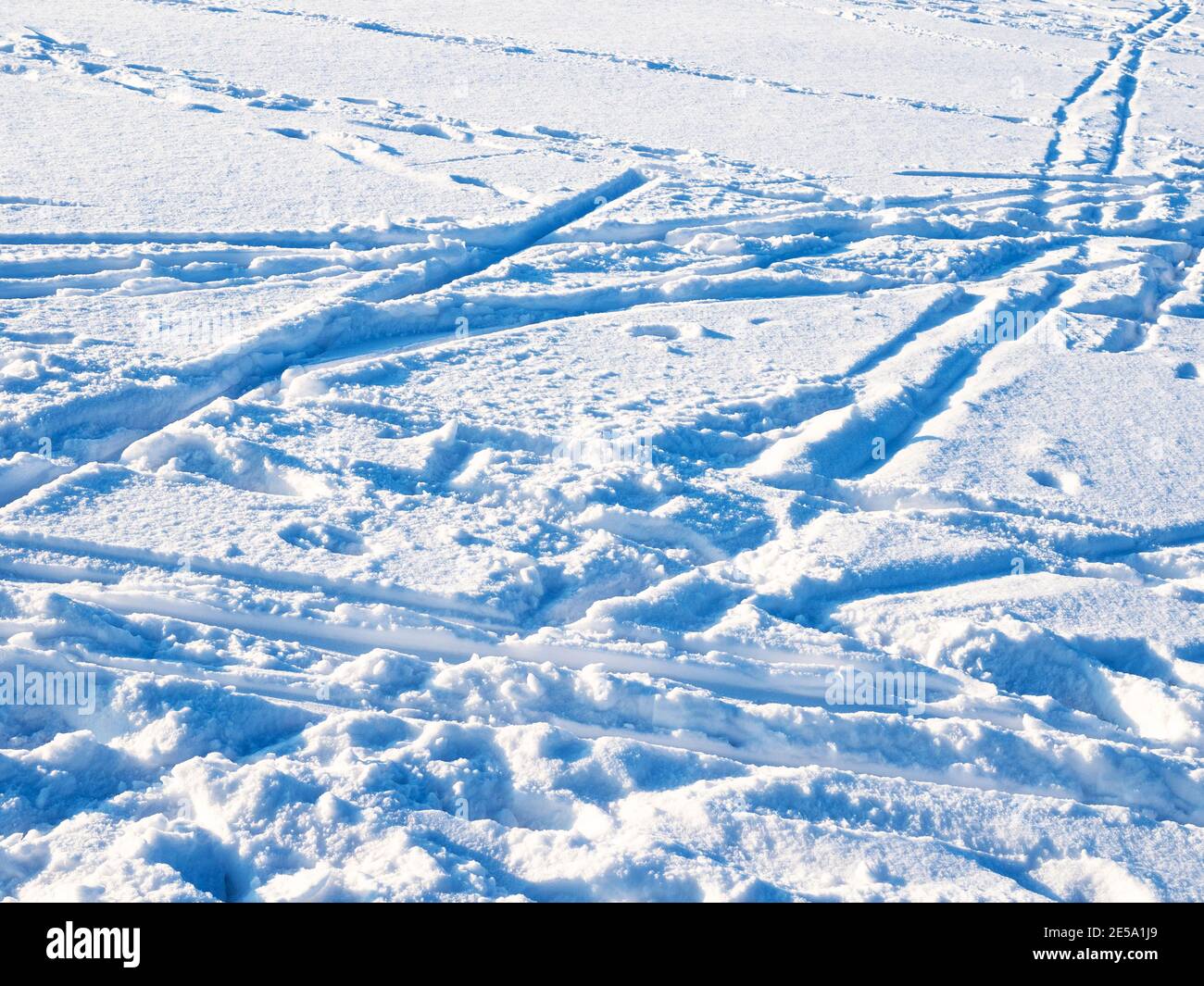 surface de neige bleue avec pistes de ski et empreintes de pas éclairées en mettant le soleil en hiver froid à deux pas Banque D'Images