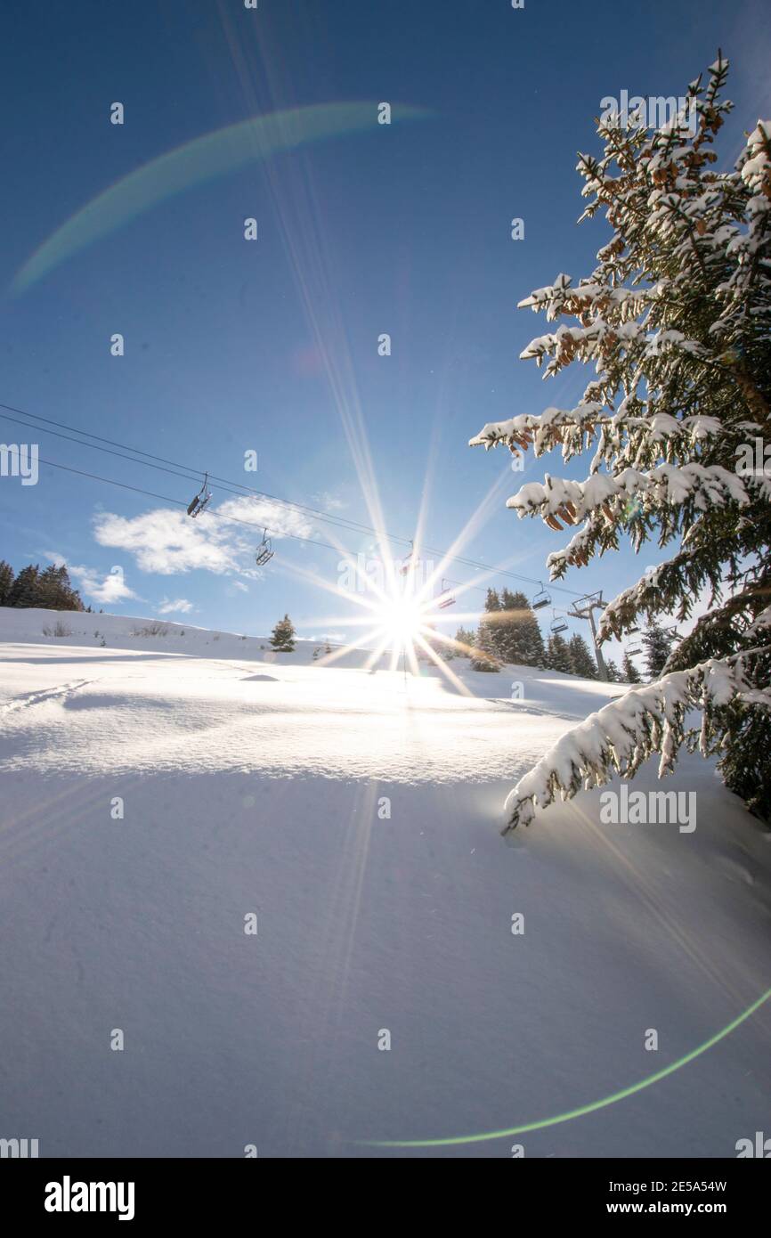 scène de montagne enneigée en hiver avec étoile de soleil et éclat d'objectif Banque D'Images