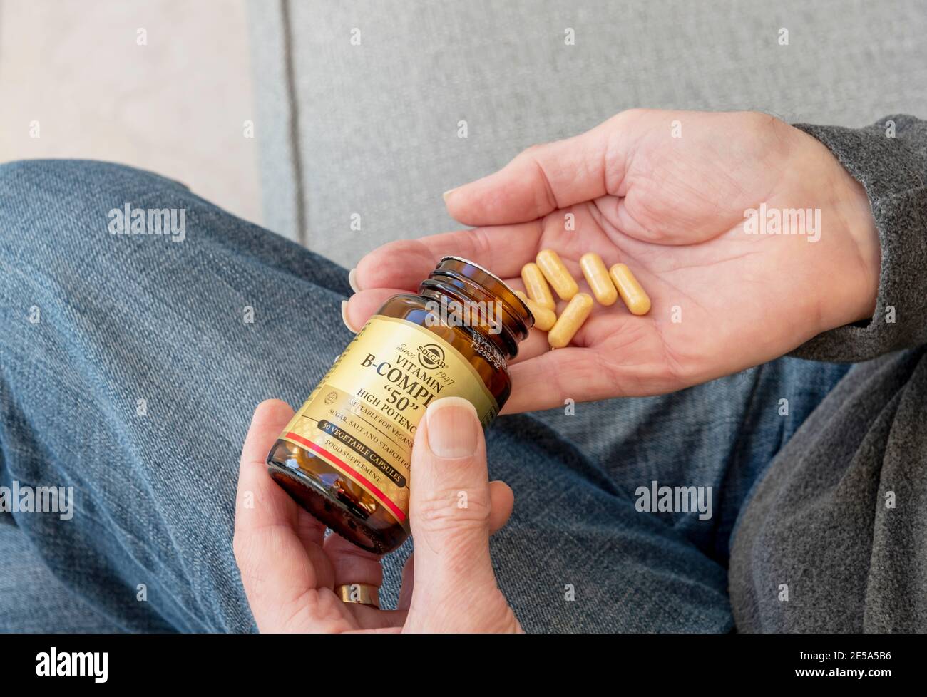 Gros plan de la personne homme tenant une bouteille de comprimés de complexe de supplément de vitamine B. Banque D'Images