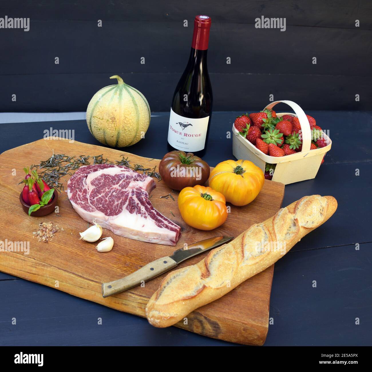 Viande Black Angus, tomates, baguette, fraises et vin rouge sur bois, France, Provence, Vaucluse, Pernes-les-Fontaines Banque D'Images