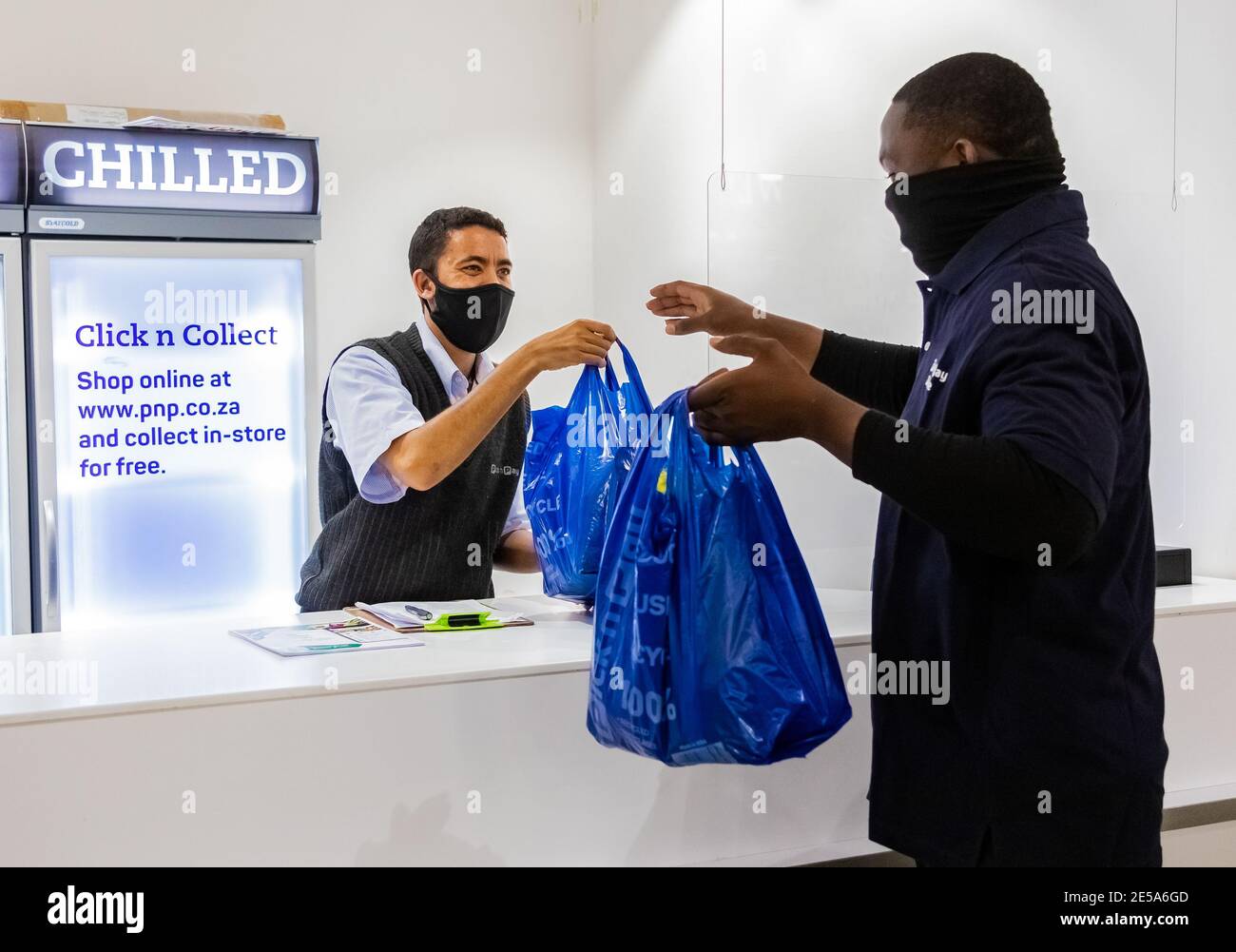 Cape Town, Afrique du Sud - 10 décembre 2020: Express Service à domicile homme de livraison de la collecte de la commande du personnel au comptoir à l'intérieur de l'épicerie locale Pick n Pay Banque D'Images