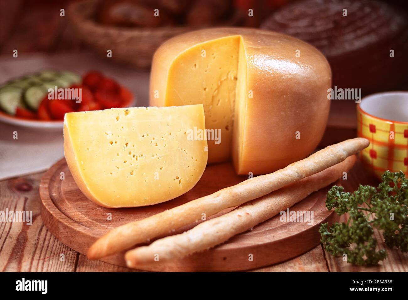 pain jaune de fromage dur sur une planche à découper, encore la vie Banque D'Images