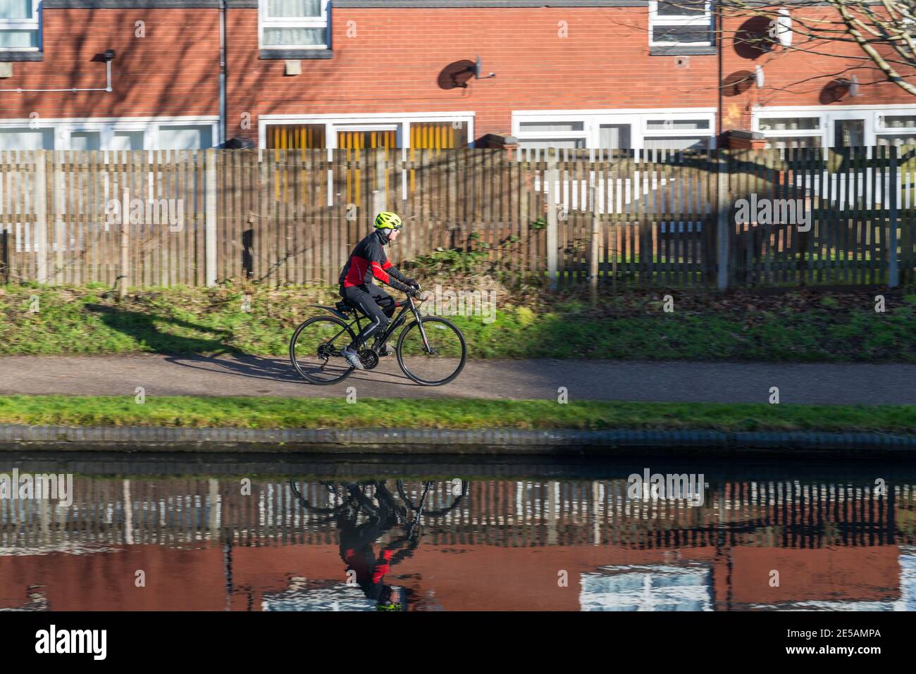 Homme pédalant le long du chemin de halage par la Birmingham Canal Old Line traversant Ladywood près du centre-ville Banque D'Images