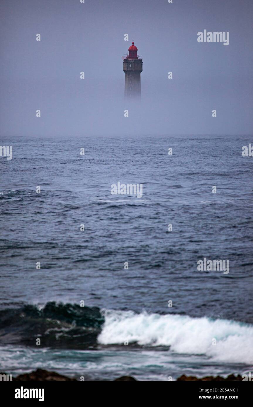 Le spectaculaire phare de la Jument, dans le brouillard estival, au large de l'Ile d'Ouessant, Bretagne. Le phare emblématique de 47 mètres de haut était bui Banque D'Images