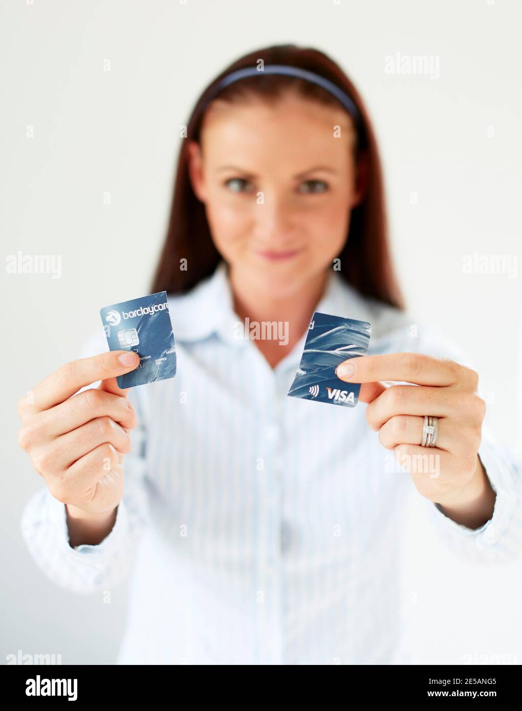 Femme tenant la carte de crédit coupée en deux Banque D'Images