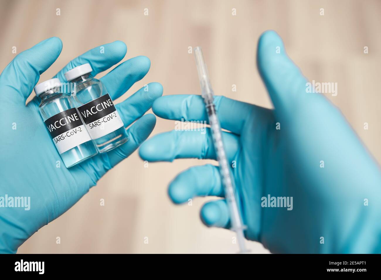 Les mains du médecin dans des gants de protection tiennent la seringue et la vaccine Banque D'Images