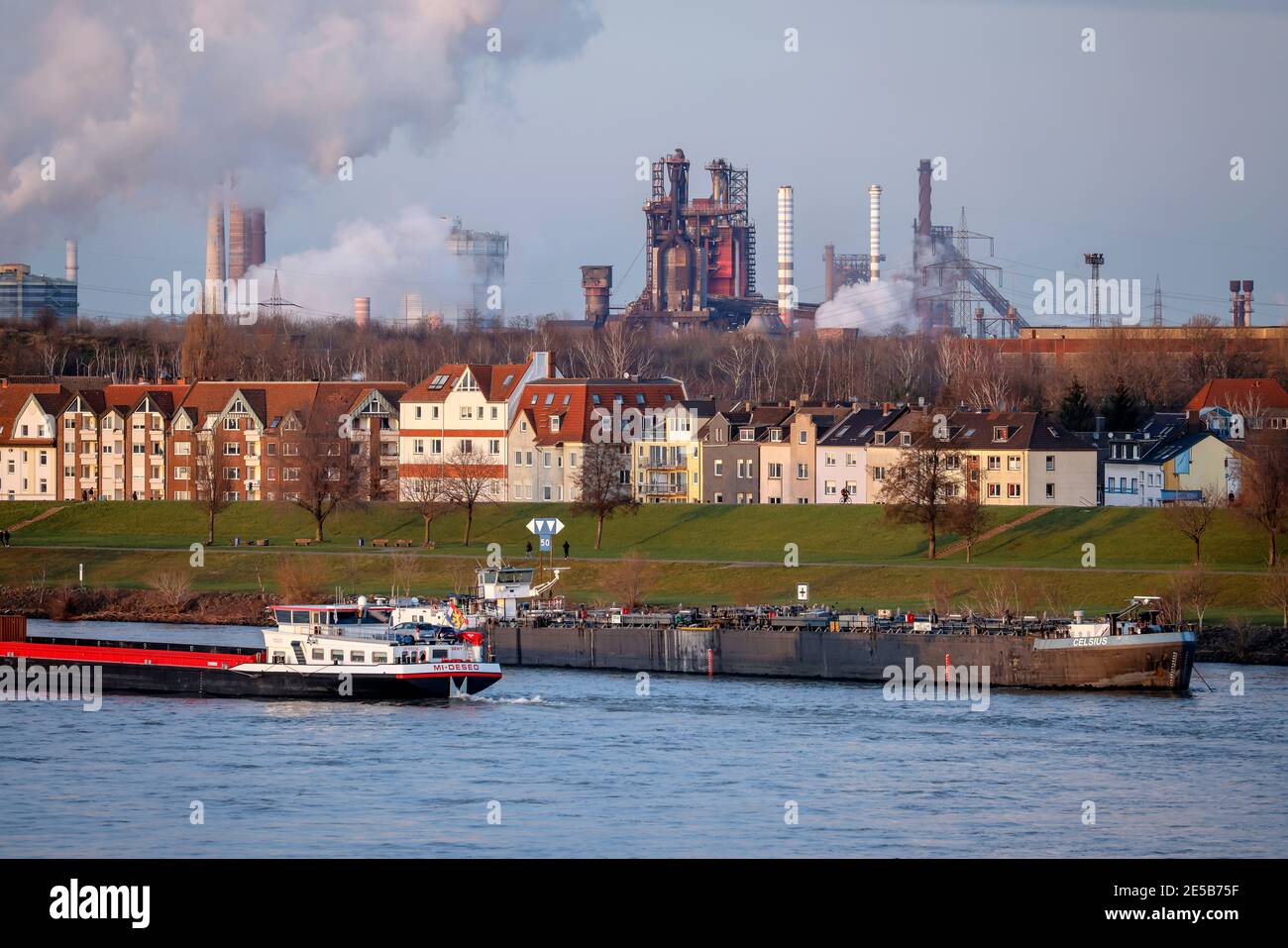 Duisburg, Rhénanie-du-Nord-Westphalie, Allemagne - Cityscape dans la région de la Ruhr avec cargo sur le Rhin en face de maisons résidentielles dans le quartier de Banque D'Images