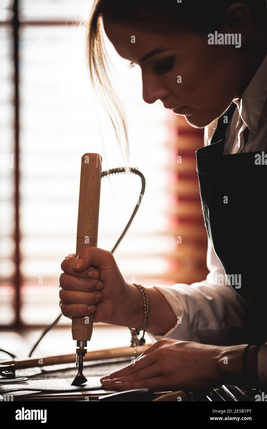 Un artisan de sac à main en cuir au travail dans un atelier vintage. Concept de petite entreprise Banque D'Images