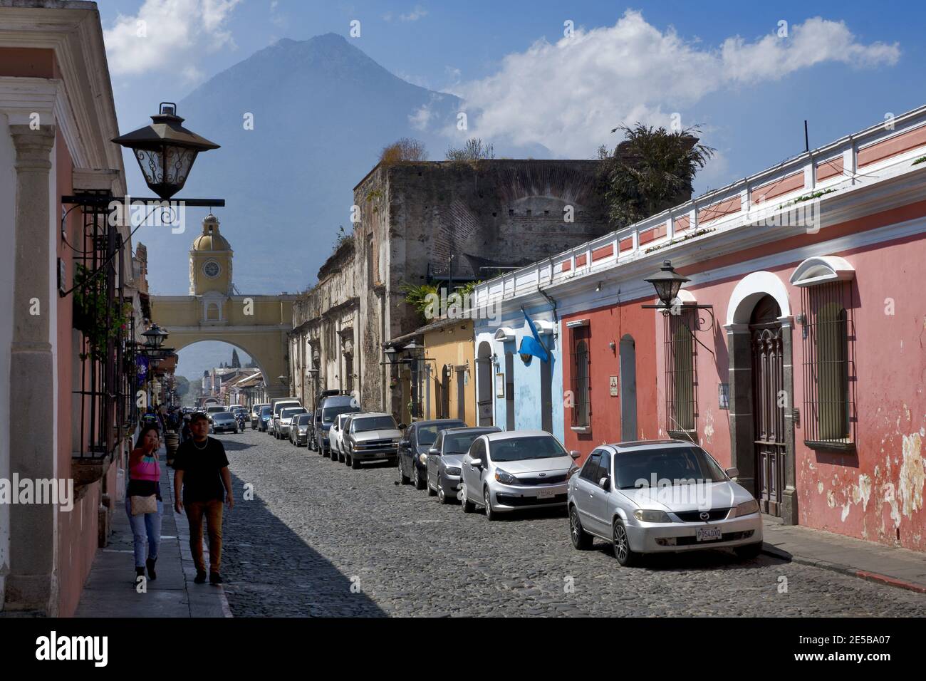 Antigua, Guatemala, Amérique centrale : volcan Agua derrière l'arche jaune de Santa Catalina, ville coloniale et site classé au patrimoine mondial de l'UNESCO Banque D'Images