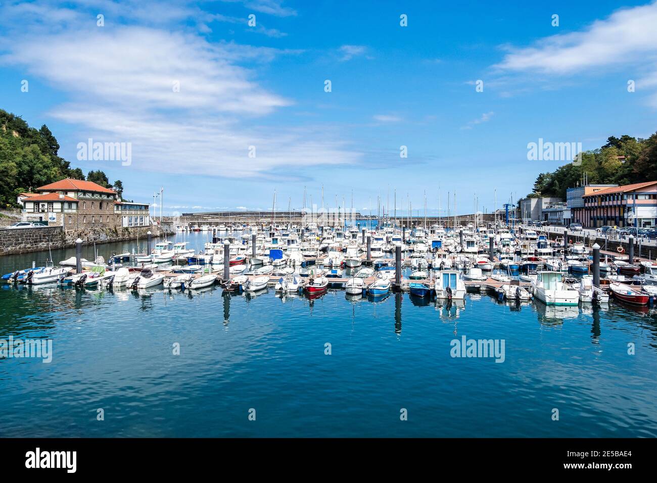 Voiliers blancs dans le port de Mutriku et la vieille ville, pays basque, Espagne. Vue sur les bateaux colorés amarrés à la marina de Motrico, face à la mer Cantabrique. Banque D'Images