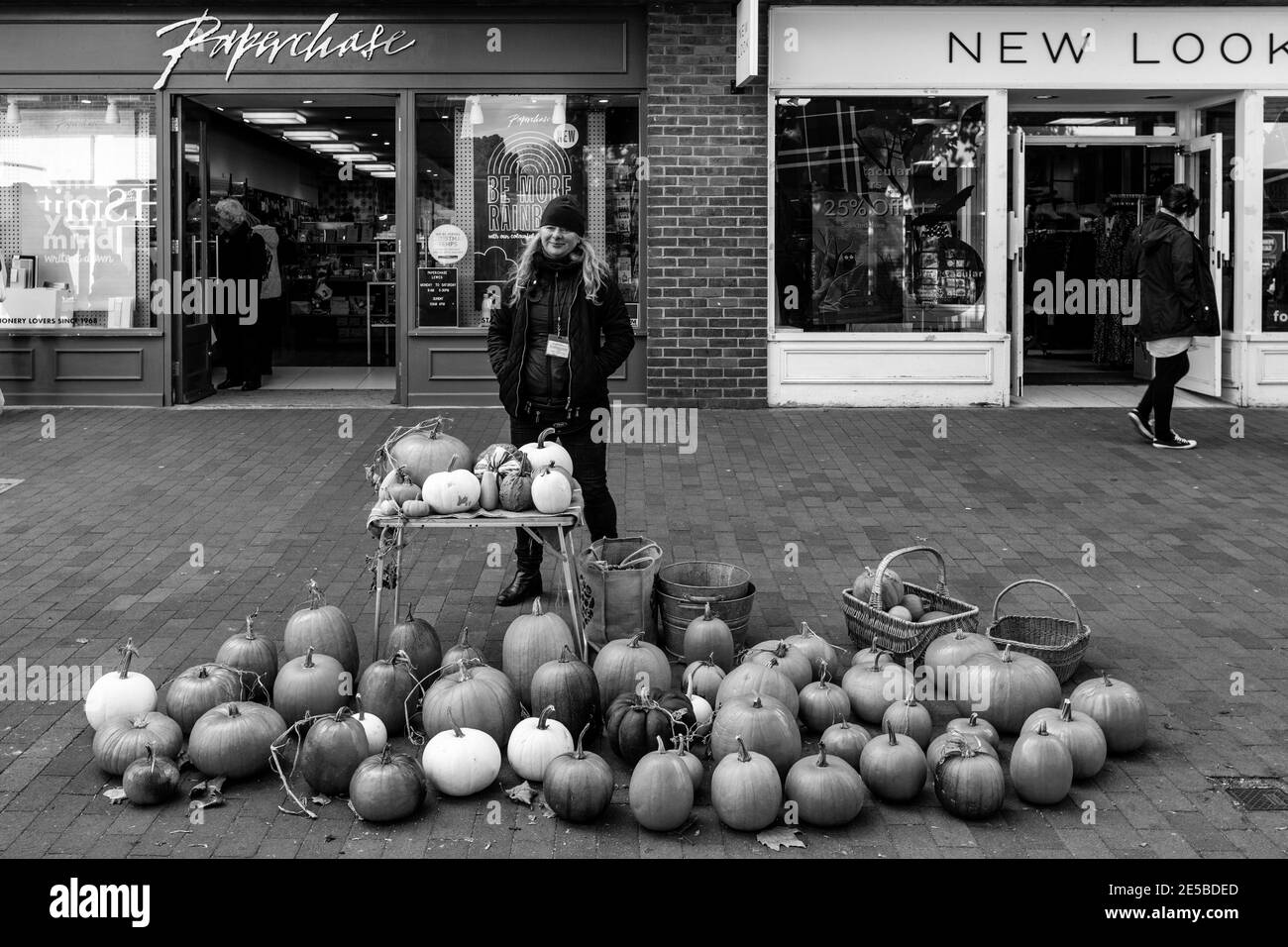 Une jeune femme vend des citrouilles et des escashes, High Street, Lewes, East Sussex, Royaume-Uni. Banque D'Images