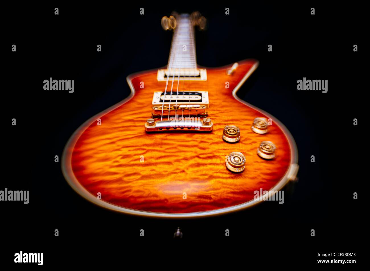 Guitare électrique vintage stylisée à faible angle avec sunburst terminer sur un fond noir Banque D'Images