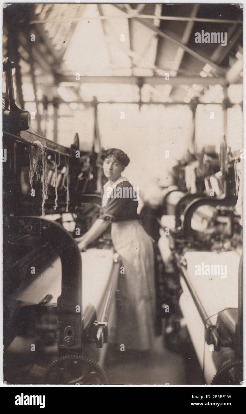 Femme ouvrier d'usine debout à la machinerie d'un moulin de coton, regardant vers la caméra. La photographie a été prise en 1914 (avant la première Guerre mondiale). Banque D'Images