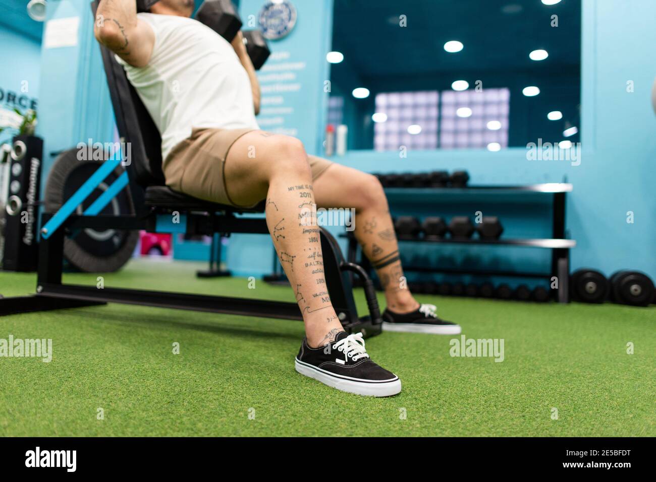 Un homme fort avec des tatouages prépare l'entraînement dans la salle de gym à concurrence Banque D'Images