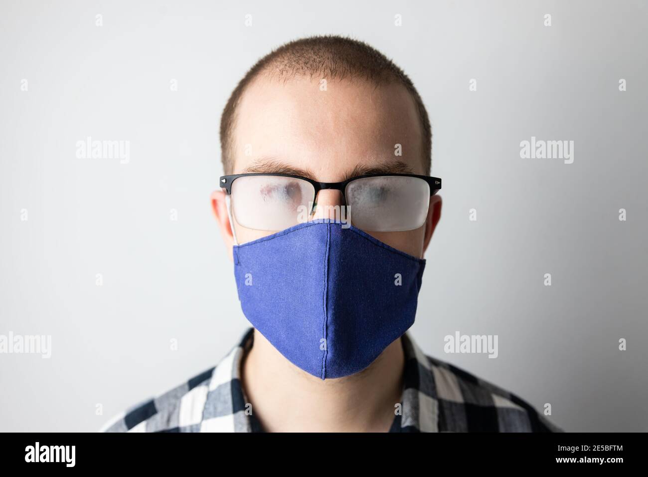 Homme portant un masque de protection et des lunettes à fogged. Nouvelles habitudes durant la pandémie de Covid-19. Le souffle chaud bouche les lunettes Banque D'Images