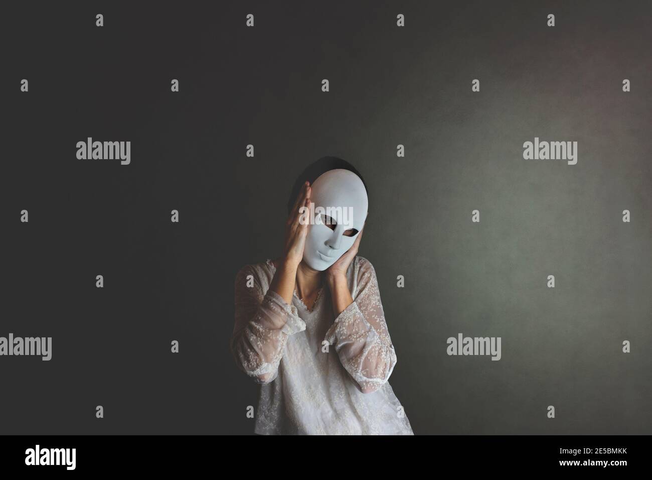 la femme couvre son visage avec un masque pour se protéger, concept de solitude et d'introspection Banque D'Images